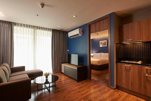 a living room with a couch and a bed at Amp Am House Bangkok Hotel in Bangkok
