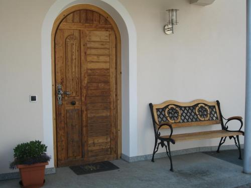 a wooden door with a bench next to a building at Gasthof Obermair in Chienes