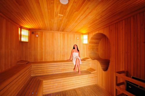 a woman is sitting in a sauna at Samara Hotel Bodrum Ultra All Inclusive in Torba