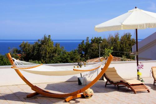 a hammock and a chair and an umbrella at Sa Fiorida case vacanze in Valledoria
