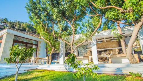a white house with trees in front of it at Icons Sea of Crete in Malia