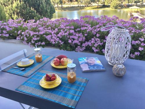 a table with plates of fruit and a book on it at Soltroia Beachouse in Troia
