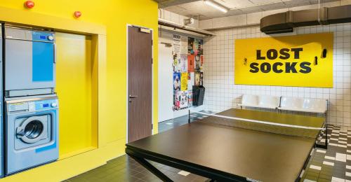 a laundry room with a table and a lost costs sign at The Social Hub Amsterdam West in Amsterdam