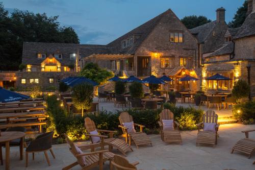 an outdoor patio with tables and chairs in front of a building at The Frogmill Hotel in Cheltenham