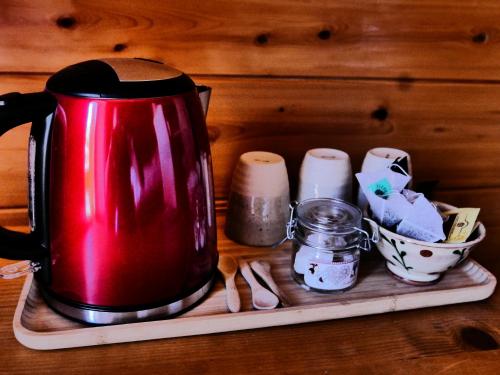 a red tea kettle sitting on a tray with spices at Chez Mamie Anna (B&B et Chalet) in Bessans