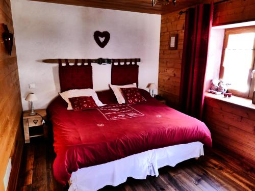 a bedroom with a red bed with a red blanket at Chez Mamie Anna (B&B et Chalet) in Bessans