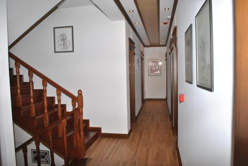 a hallway with wooden stairs and white walls at Hotel Kastro in Gjirokastër