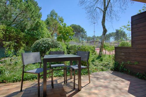 a table and two chairs on a patio at Hotel Résidence Le Sporting in Cap-Ferret