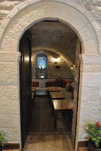 an archway in a restaurant with tables and couches at Hotel Kastro in Gjirokastër