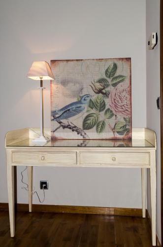a table with a lamp and a painting on it at Hotel Presa in Riaño