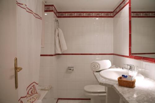 a white bathroom with a sink and a toilet at Hotel Vostra Llar in Palamós