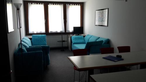 a waiting room with blue chairs and a table at Multiproprietà Rio Falzè in Madonna di Campiglio