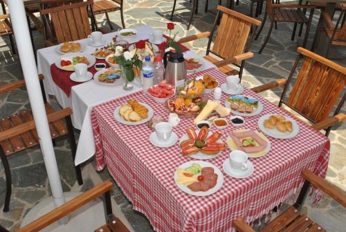 a table with food on a red and white table cloth at Hotel Kastro in Gjirokastër