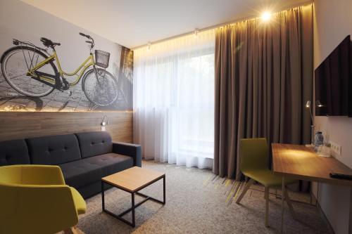 a living room with a blue couch and a bike on the wall at Active Hotel in Wrocław