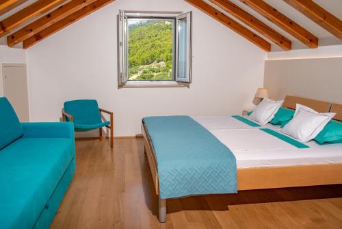 ein Schlafzimmer mit einem Bett, einem Fenster und einem Sofa in der Unterkunft Villa Franka with pool in Bol