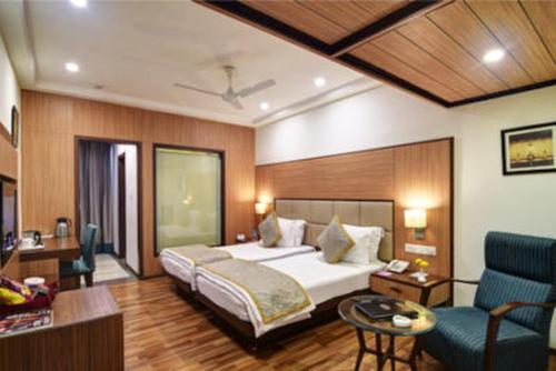 een hotelkamer met een bed en een woonkamer bij Hotel Chanakya in Patna
