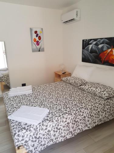 a bedroom with a bed with a black and white comforter at Il Daviduccio Suite in Siracusa