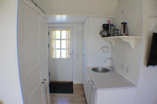 uma pequena cozinha com um lavatório e uma janela em Klitgaarden Henne Strand em Henne Strand