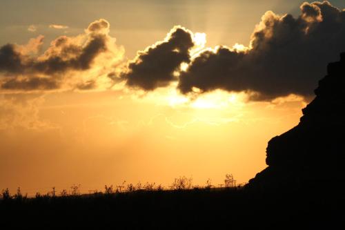a sunset over a field with clouds in the sky at Fosstún Guesthouse in Skogar