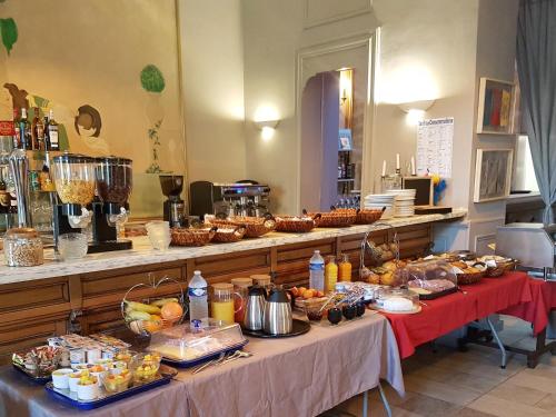 a buffet of food on two tables in a room at Le Grand Hôtel Molière in Pézenas
