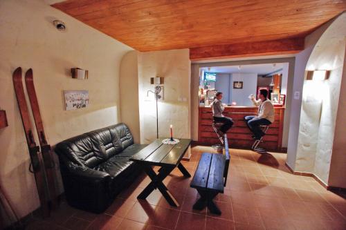 a living room with a black leather couch and a table at Pod Orlicą in Duszniki Zdrój