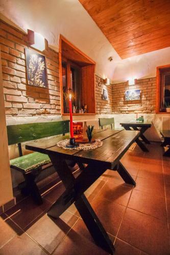 a dining room with a wooden table and benches at Pod Orlicą in Duszniki Zdrój