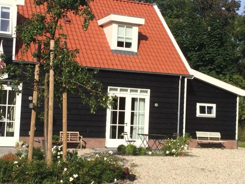 a black house with an orange roof at Hof Olmenstein in Goes