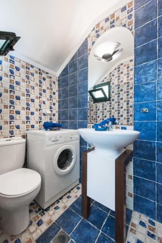 a bathroom with a toilet sink and a washing machine at Kriopigi Pines by the Sea by Luxlikehome in Kriopigi