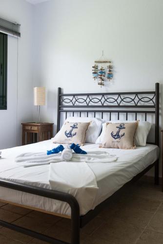 a large bed with white sheets and pillows at Kriopigi Pines by the Sea by Luxlikehome in Kriopigi