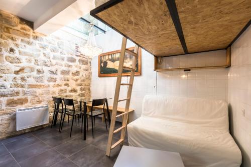 パリにあるAttractive 25 m2 in a central districtのベッド、テーブル、椅子が備わる客室です。