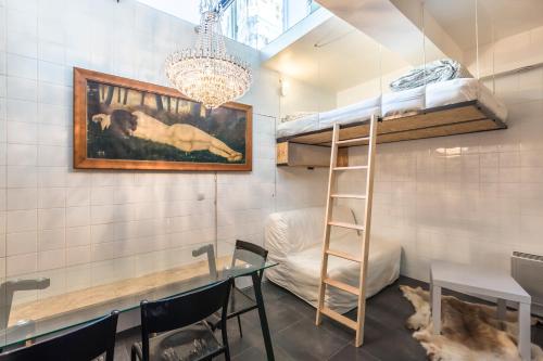 パリにあるAttractive 25 m2 in a central districtのダイニングテーブルと二段ベッドが備わる客室です。