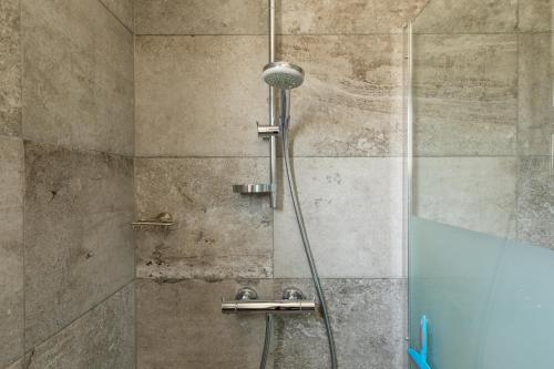 a shower with a glass door in a bathroom at Appartement De Parel, Resort Amelander Kaap in Hollum