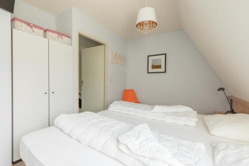 two beds in a room with white walls at Appartement De Parel, Resort Amelander Kaap in Hollum