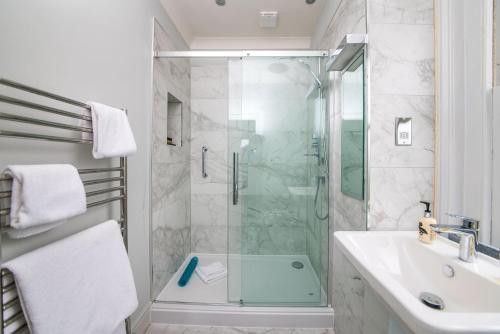 a bathroom with a glass shower and a sink at The Ayrlington Guesthouse in Bath