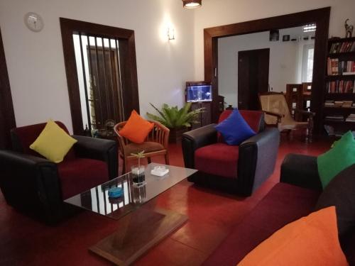 a living room with colorful chairs and a table at Mahaweli Shades in Kandy