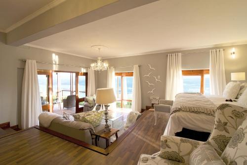 a large bedroom with a bed and a chandelier at Kambaku @ Sea in Sedgefield