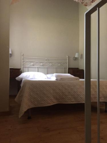 a bedroom with a bed with white sheets and pillows at Relais Real Collegio in Noli