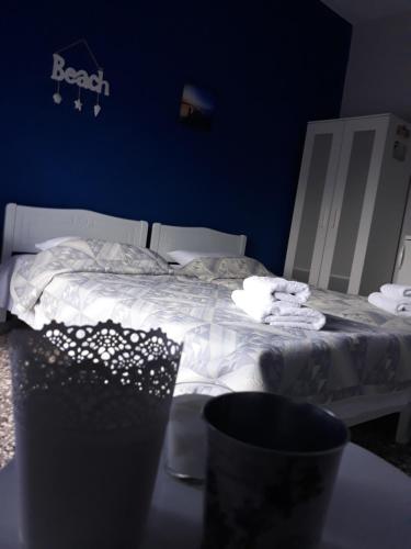 a bedroom with a bed with a blue wall and a table at Meerithic ROKKA ROOMS in Vourvourou