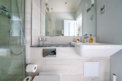 a bathroom with a sink and a toilet and a shower at The Ayrlington Guesthouse in Bath