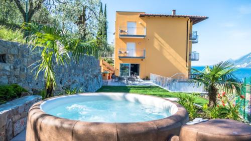 a hot tub in a garden with a building at Hotel Casa Marinella in Malcesine