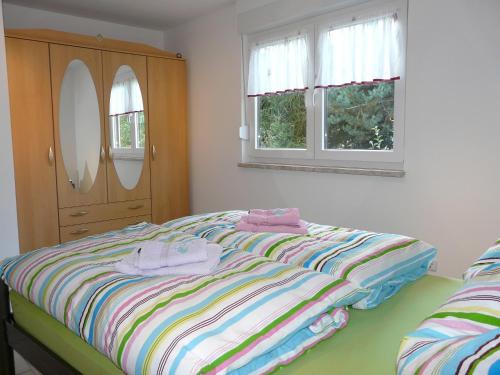 a bedroom with a bed and a dresser and two windows at Ferienhaus Uda in Schwarzenberg