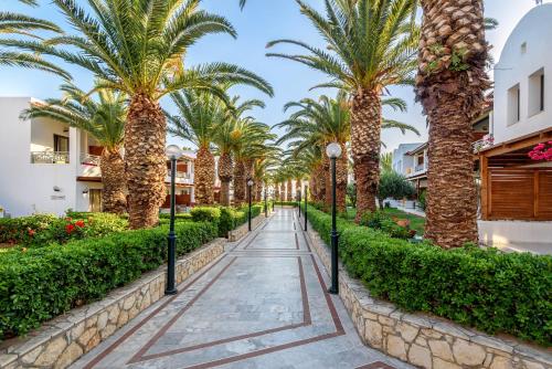 a walkway lined with palm trees in a resort at Annabelle Beach Resort in Hersonissos