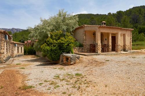 a small stone house in a field with a tree at Casas rurales amable- yeste in Cortijo Prados