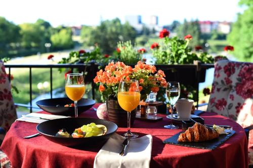 a table with plates of food and glasses of orange juice at Romantic Boutique Hotel & Spa in Panevėžys