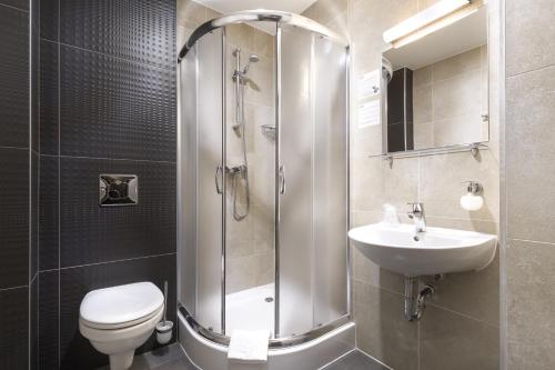 a bathroom with a shower and a toilet and a sink at Hotel Picaro Kraśnik Dolny in Bolesławiec