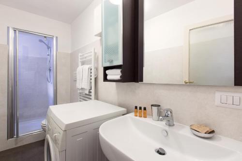 a white bathroom with a sink and a mirror at ROMAC Villa Medici 3-Bedroom Holiday Apartment near Spanish Steps in Rome
