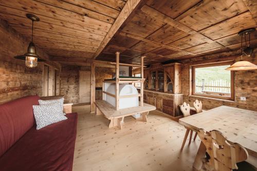 uma sala de estar com uma mesa e um fogão numa cabina em Hirschhof Pfrein - Hideaway em Chiusa
