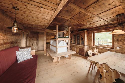 a living room with a table and a stove in a cabin at Hirschhof Pfrein - Hideaway in Chiusa