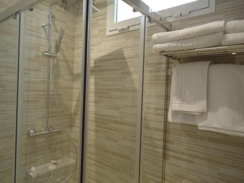 y baño con ducha y puerta de cristal. en Apartamentos Acevedo Centro, en Ronda