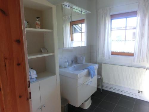 a white bathroom with a sink and a mirror at Kastanienhof in Kalleby